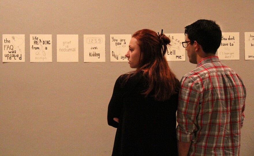 WORD ART — Courtney Mcgovern, 21, and Daniel Diaz, 21, support their friend, Wes Riley, whose art was shown at The Wooly on Friday. “It’s all very unique,” Mcgovern said. (photo by Christena Carollo)