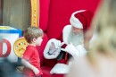 Charles Graves, portraying Santa Claus, uses sign language to communicate with a deaf child.