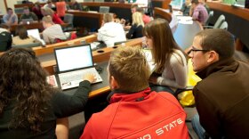 Students gather around a laptop computer in an Ohio State University classroom.