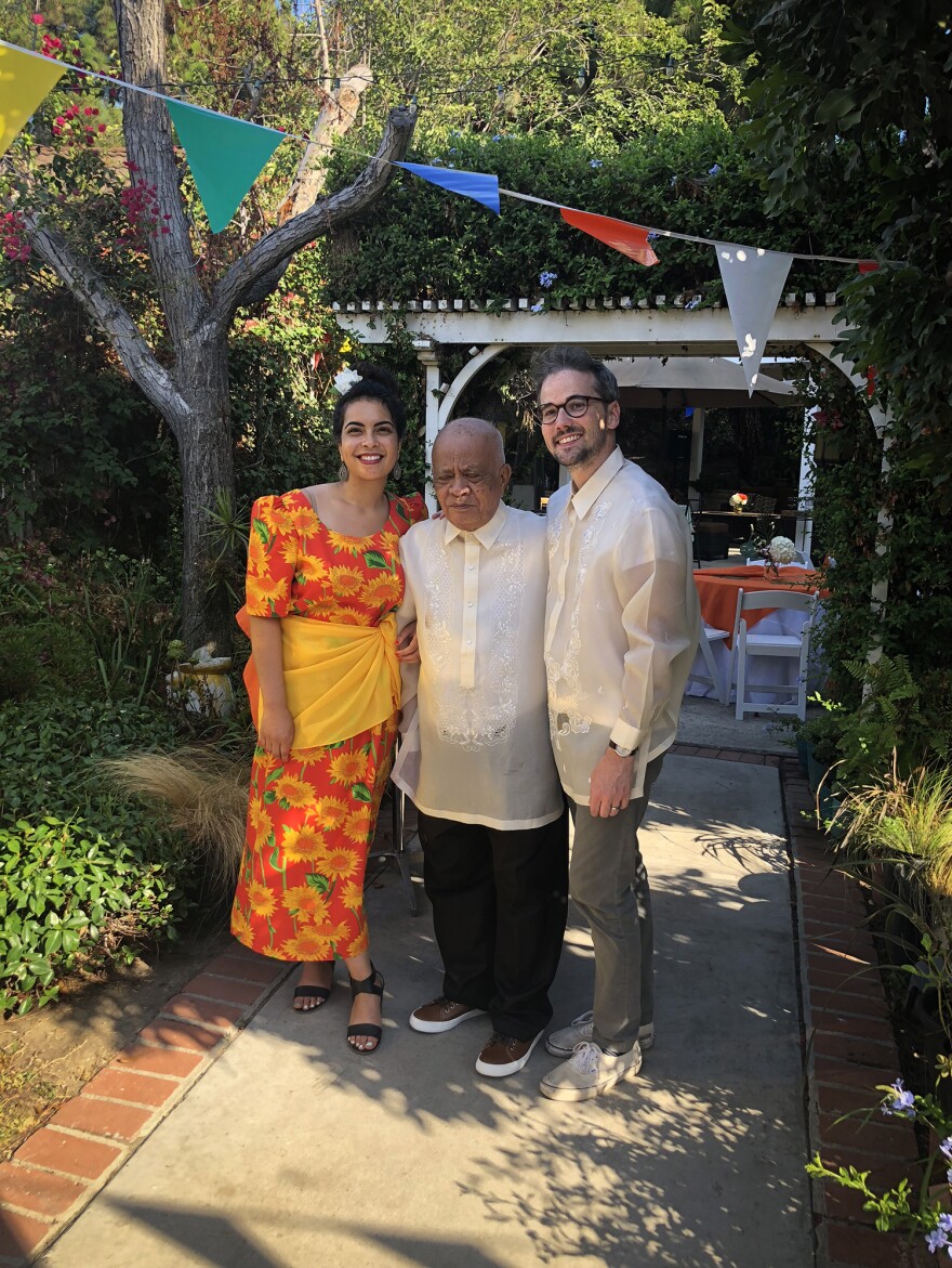 Malaka Gharib, her grandfather Floro Mercene and her husband, Darren Vandergriff, wear traditional Filipino clothing at her grandfather's birthday party.