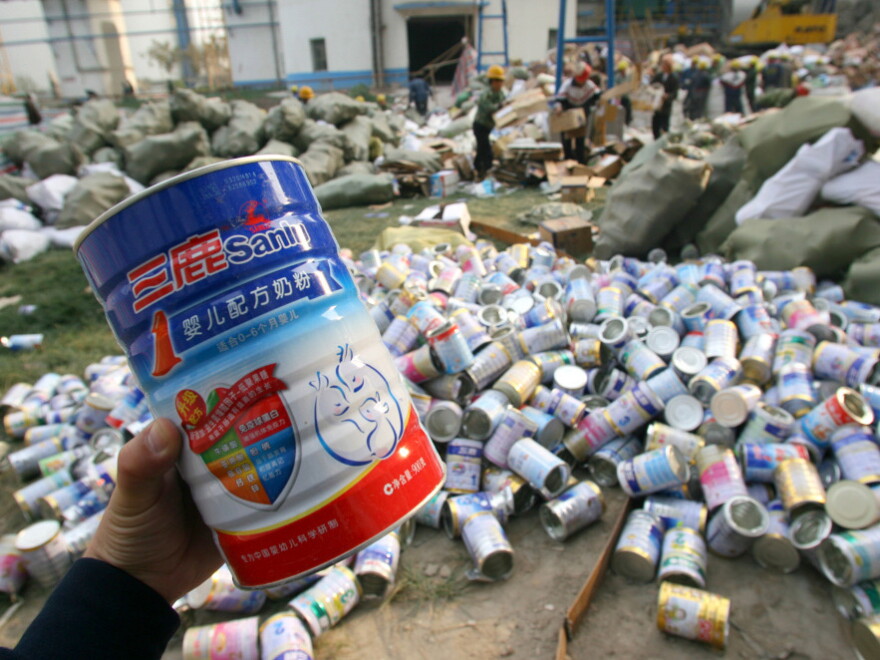 Factory workers pile up empty tins after the melamine-contaminated Sanlu milk powder was poured into bags for destruction at a cement plant in Shijiazhuang city, north Hebei province, on Oct. 14, 2008.