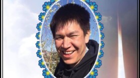 A photograph of a smiling man, with a flower border around it.