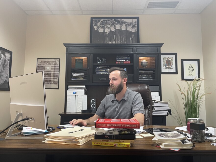 Ohio Patrolmen's Benevolent Association general counsel Dom Saturday works on his computer at his desk filled with books and paperwork. 