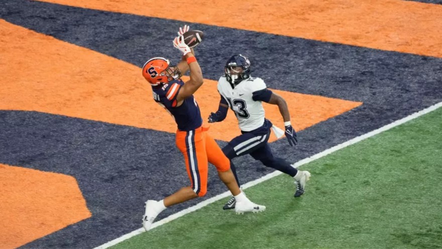 Oronde Gadsden (19, navy) jumping for a touchdown