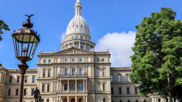 The Michigan Capitol building in Lansing, featuring a lamppost and the Gov. Blair statue.