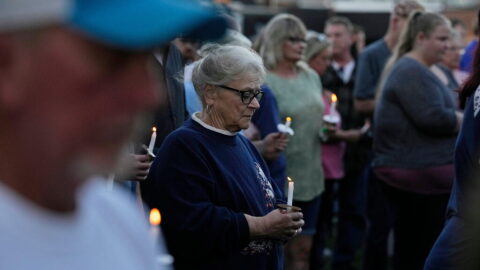 A woman holds a candle vigil honoring the victims of a blast at an explosives plant, Accurate Energetic Systems, Sunday, Oct. 12, 2025, in Waverly, Tenn. (AP Photo/George Walker IV)