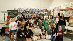 Milwaukee Diaper Mission founder Meagan Johnson (top far right) along with MDM staff and volunteers in their warehouse.