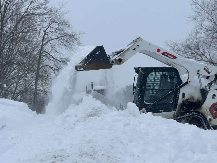 Image, large machine dumping snow.
