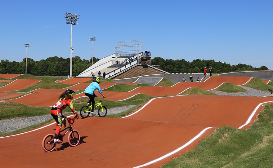 A rolling course is rehearsed by a media member and coach, heading for the finish line at the Rock Hill BMX track.