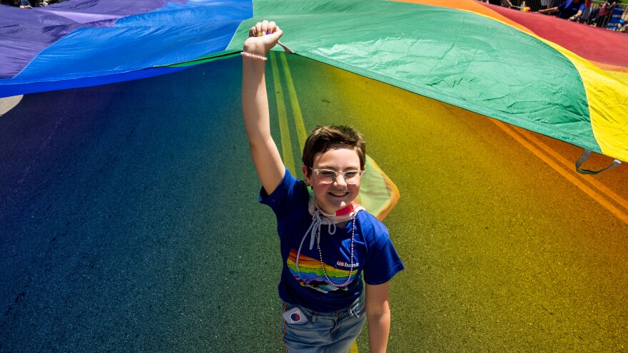 Sophia Lewis, 13, of Maryland Heights, Mo., helps hoist a giant rainbow flag down Market Street on Sunday, June 25, 2023, during the St. Louis PrideFest Parade in downtown St. Louis.