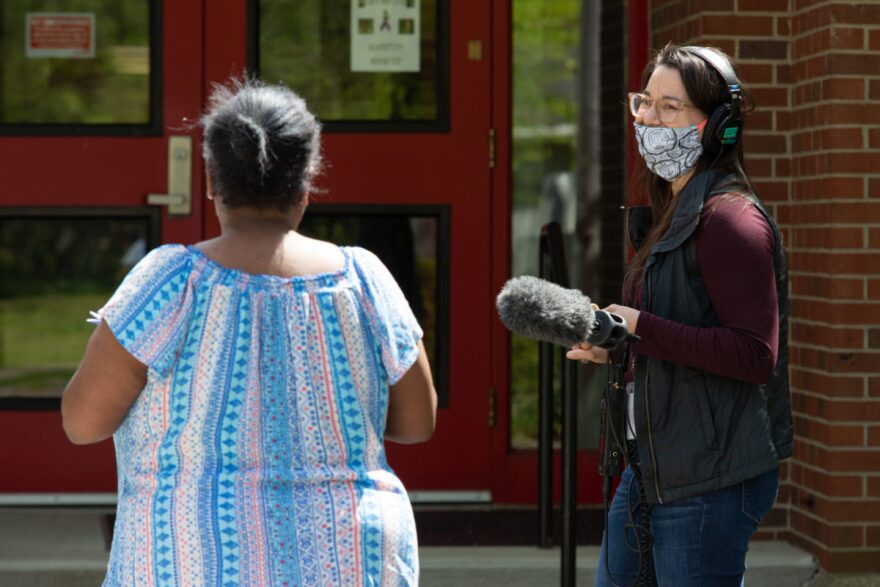 Reporter Jess Clark interviews a parent at Phillis Wheatley Elementary School on April 22, 2020.