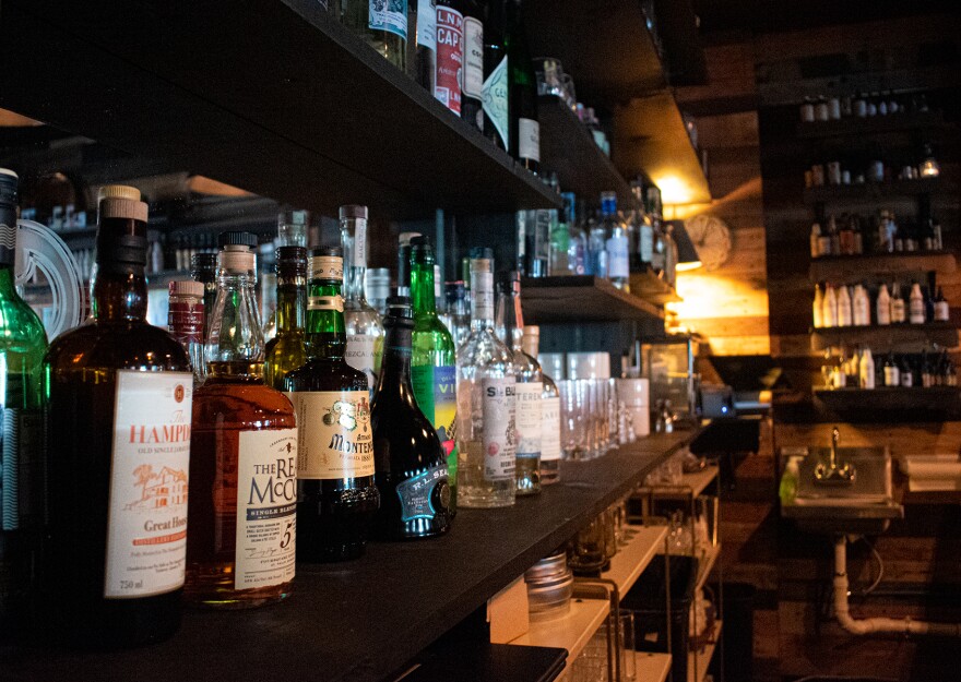 Liquor bottles line the back of a bar in this July 2022 file photo.