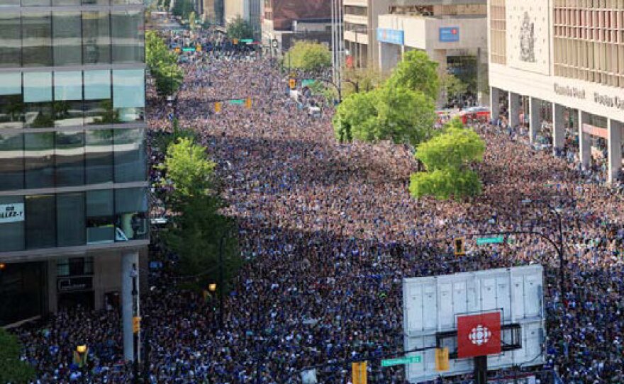 In this image taken from the published review of the Vancouver, B.C., riots, a mass of 155,000 people can be seen gathered to watch the Canucks play the Boston Bruins in the Stanley Cup final. The report says the crowd got too big too fast.