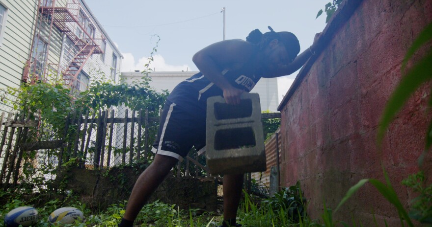 rugby player lifting cinderblock