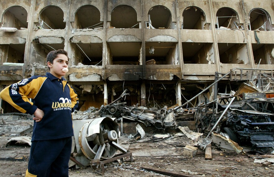 Jan. 28, 2004: A boy stands at the scene of a car bombing in front of a hotel, that killed at least three people in Baghdad. A suicide bomber blew up the explosive packed car in front of the Shaheen hotel that is frequented by many westerners and where Iraq's labor minister lived.