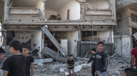 Palestinians inspect damage to buildings in Al-Saftawi street northern Gaza City on May 20, 2021 in Gaza City, Gaza. (Fatima Shbair/Getty Images)