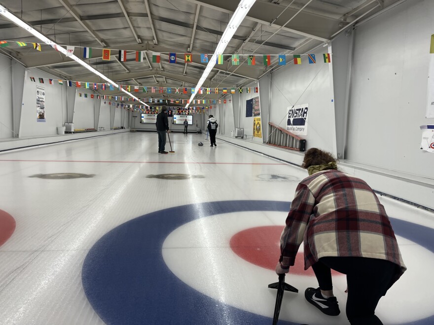 "Hometown, Alaska" host, Kim Sherry (right) gets a lesson from members of the Anchorage Curling Club.