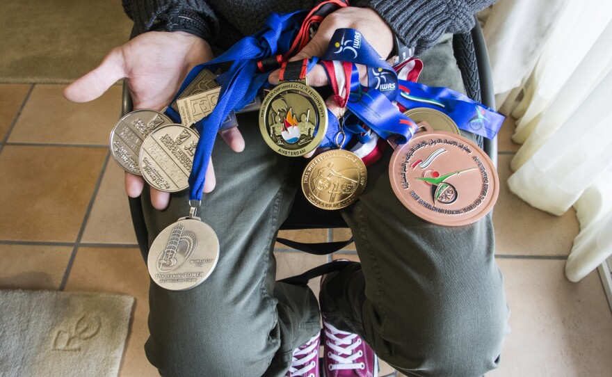 Triantafyllou shows some of the medals he's won over the years, including the gold he won last November at the Wheelchair Fencing World Cup in Amsterdam.