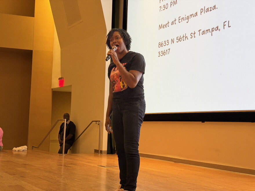 Woman speaking into a microphone on stage