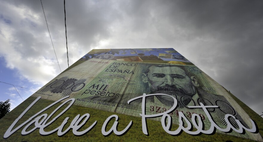 A poster reading "The peseta is back" stands in Salvaterra de Mino, northwestern Spain. Some areas in Spain are returning to their former currency to make extra cash during the debt crisis.