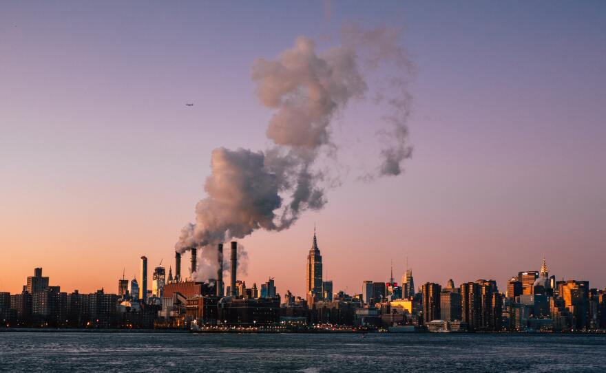 The New York City skyline with smokestacks. 