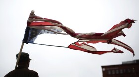 A protester stands outside the Thomas F. Eagleton federal courthouse in downtown St. Louis as Attorney General Jeff Sessions delivers a tough-on-crime message to local law enforcement leaders in March.