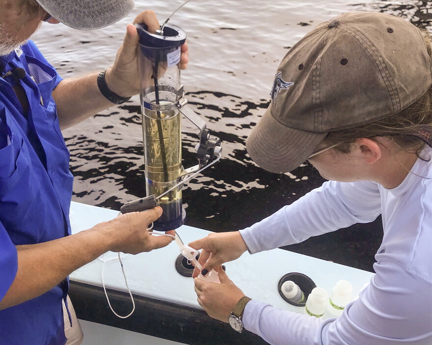 Dr. Bill Mitsch and Ph.D. student Lauren Griffiths take a water sample from the Caloosahatchee River to determine where the nitrogen in the water originated. 
