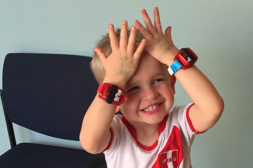 Noah Drozda shows off a pair of biosensors that he wore around the clock for a study on motor deficits in children.