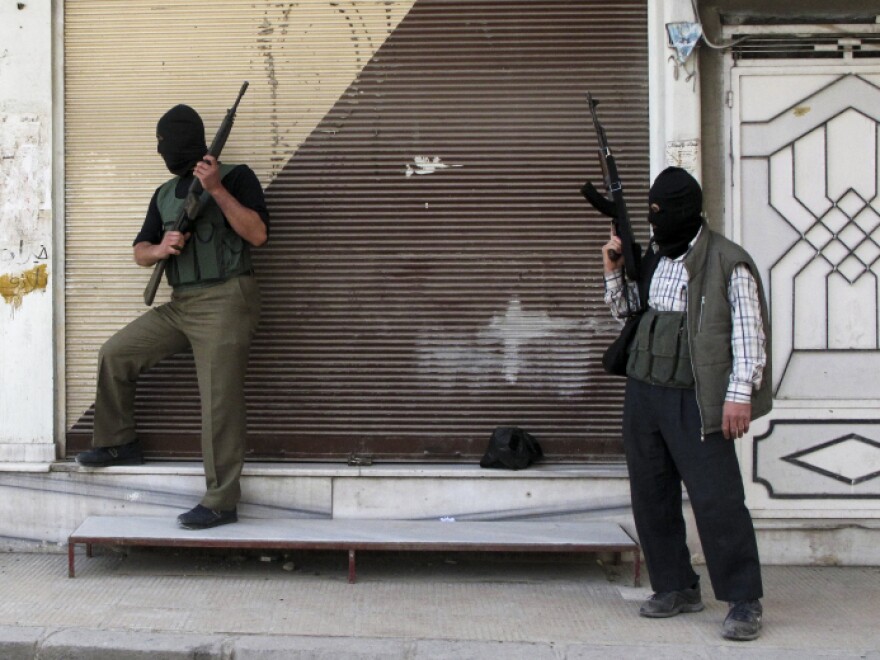 Syrian opposition fighters stand watch in a suburb of Damascus, Syria, on April 6. A cease-fire was declared several days later, but shooting has continued.