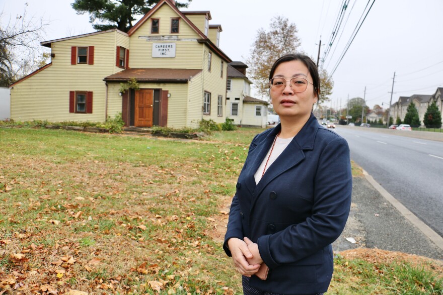 Thao Le stands beside two properties she owns on Route 130 in Cinnaminson Township.