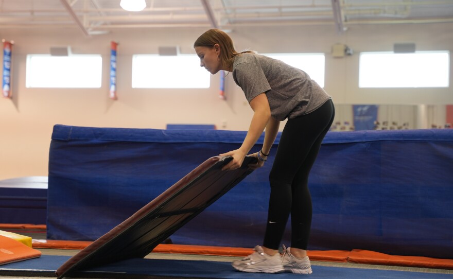 UF gymnastics student manager Peyton Harbert sets up equipment for a gymnast. She has been working as a member of head coach Jenny Rowland's staff since her freshman year. (Alexis Vivanco/WUFT Sports)