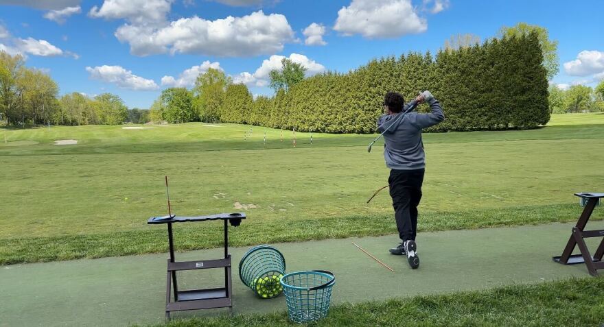 Gary Innes, a tennis professional, hits a golf ball at the driving range at the Portage Country Club on May 14, 2026.