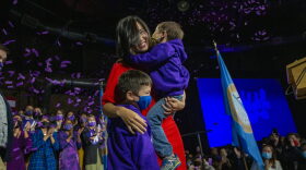 Newly elected mayor of Boston Michelle Wu embraces her sons Cass and Blaise on stage at the Cyclorama.