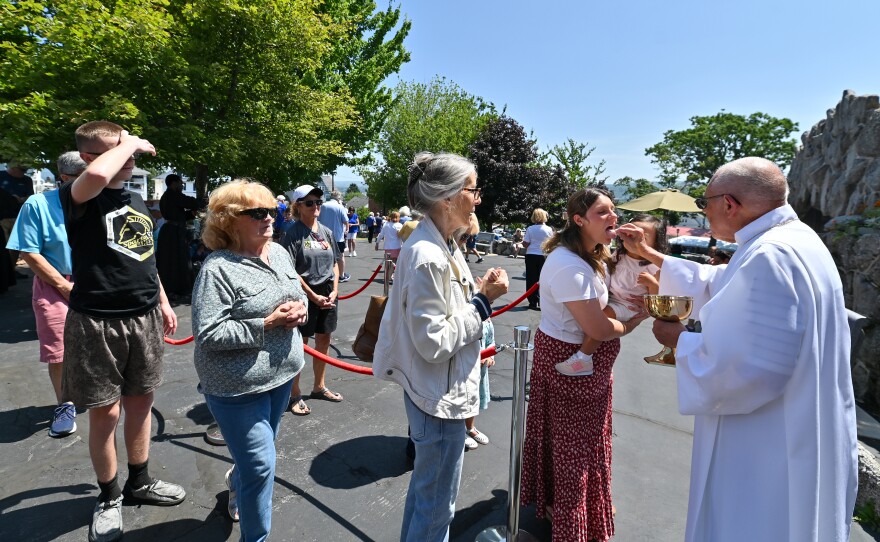 Parishioners receive communion at St. Ann's during Mass monday.