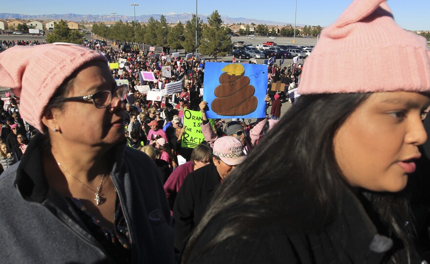 Protesters carry signs as they make their way to Sam Boyd Stadium on Sunday.