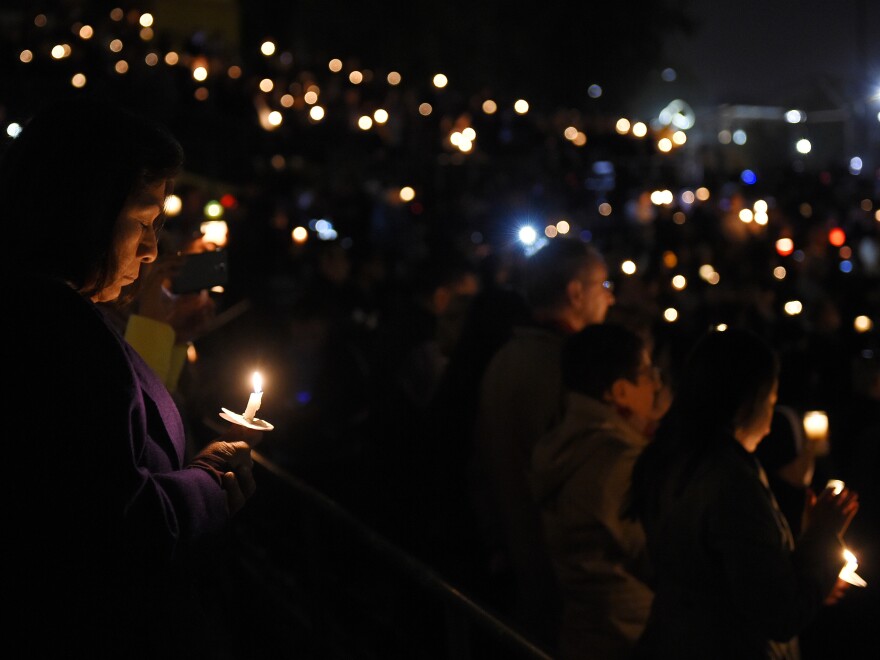 People hold candles during a vigil for shooting victims in San Bernardino, California.