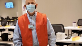 Volunteer Robert Mertzlufft wears a red vest so patients can easily find him when he works at the St. Luke's COVID-19 vaccine clinic inside the Chesterfield Mall.