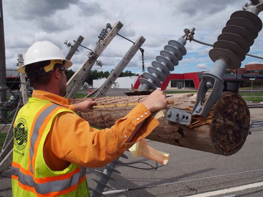 Work being done on Orchard Lake Rd where a power pole fell.