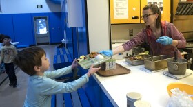 Dani Koschak passes a hot lunch to a student at Moose Pass School. The small school serves students grades kindergarten through 8.