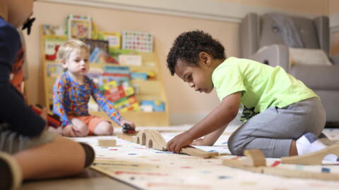 A child plays with a train set at Bumble Art Studio day care center in Astoria, Ore., Friday, Sept. 2, 2022. (Craig Mitchelldyer/AP)