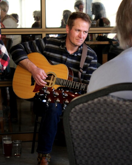 A man sits with his guitar.