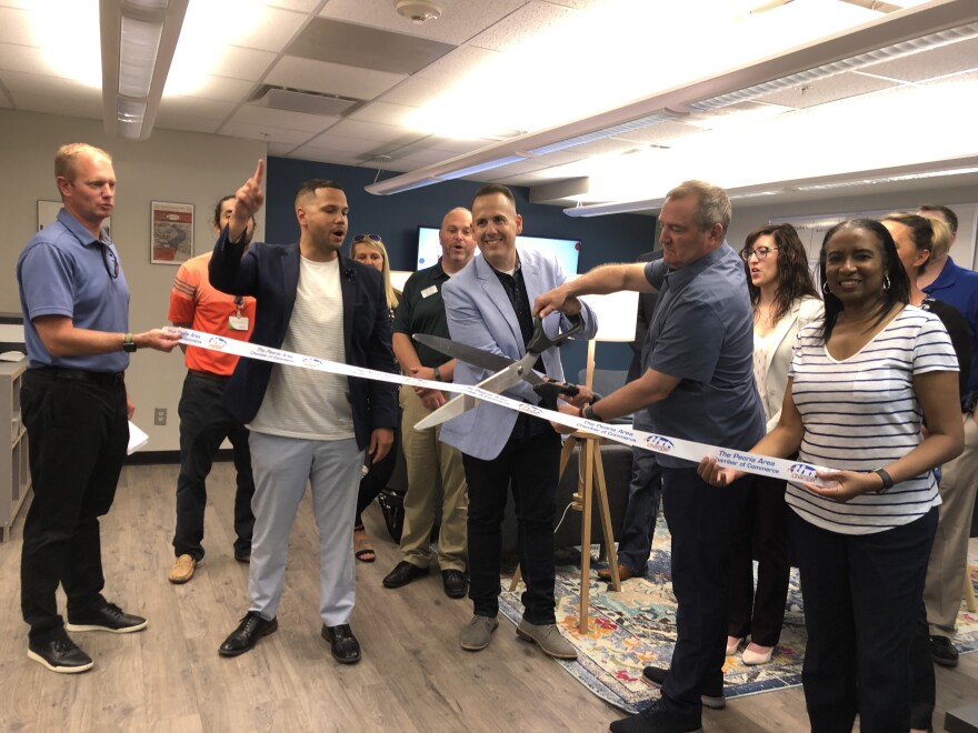 Peoria Innovation Alliance Executive Director Jake Hamann and Board President Philip Lockwood prepare to cut the ribbon as Peoria Area Chamber of Commerce President and CEO Joshua Gunn counts down Wednesday during the opening of the Center for Civic Innovation in downtown Peoria.