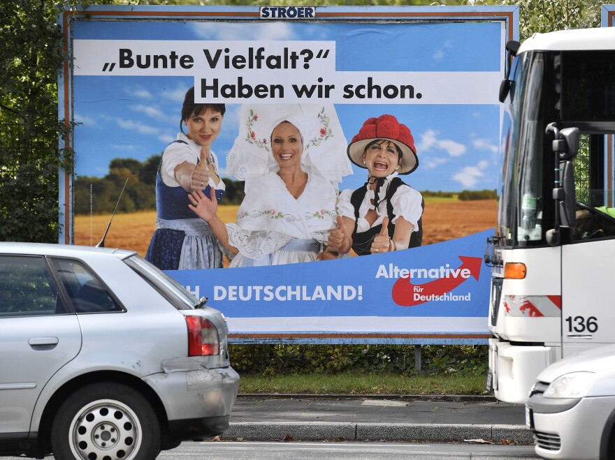 A poster in Essen showing women in traditional German dress promotes the far-right party Alternative for Germany. The poster says, "Colorful variety? We have already."