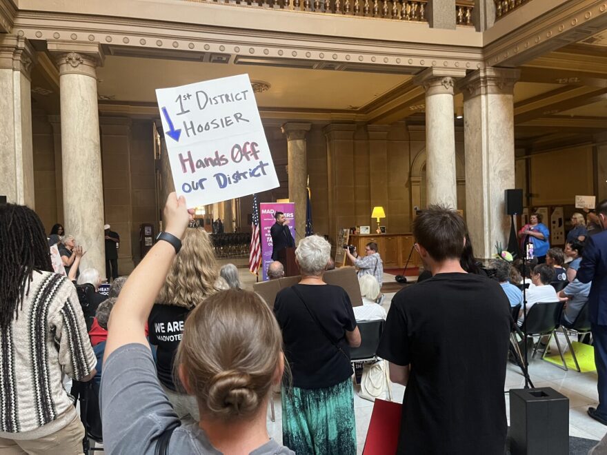 protestors holding signs against redistricting in the Indiana statehouse atrium
