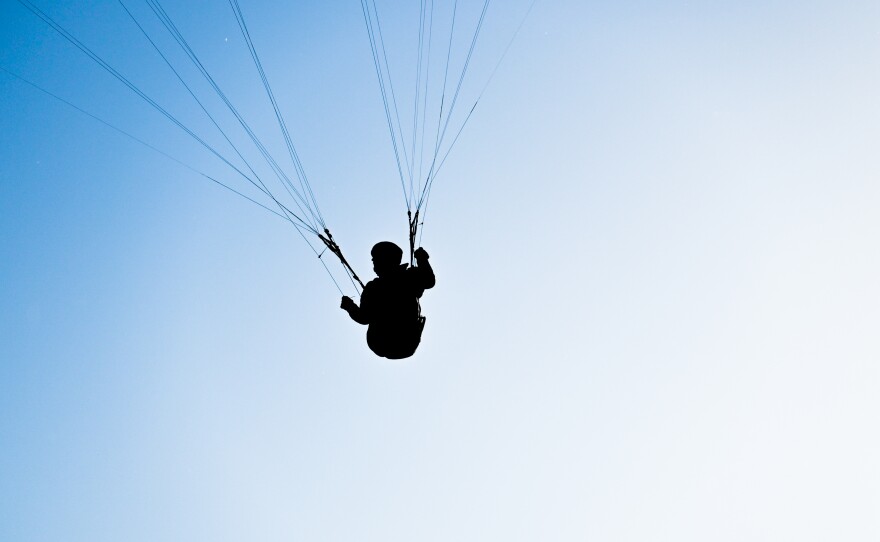 Skydiver is head down flying over a spectacular mountain scenery