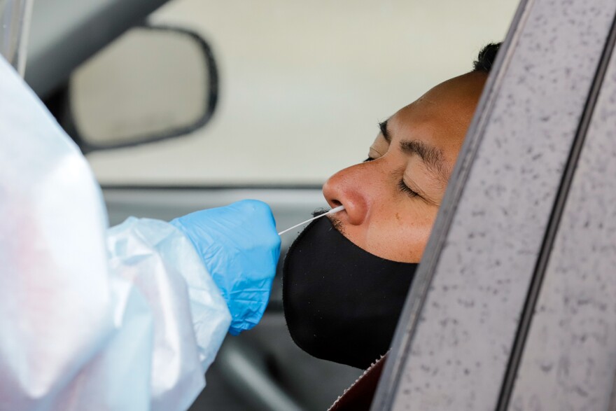 a medical professional swabs a driver's nostril