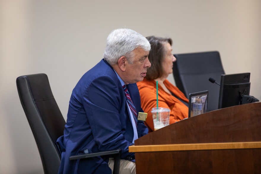 Board members David Perry, left, and Judy Justice, right, on dais in July 2025.