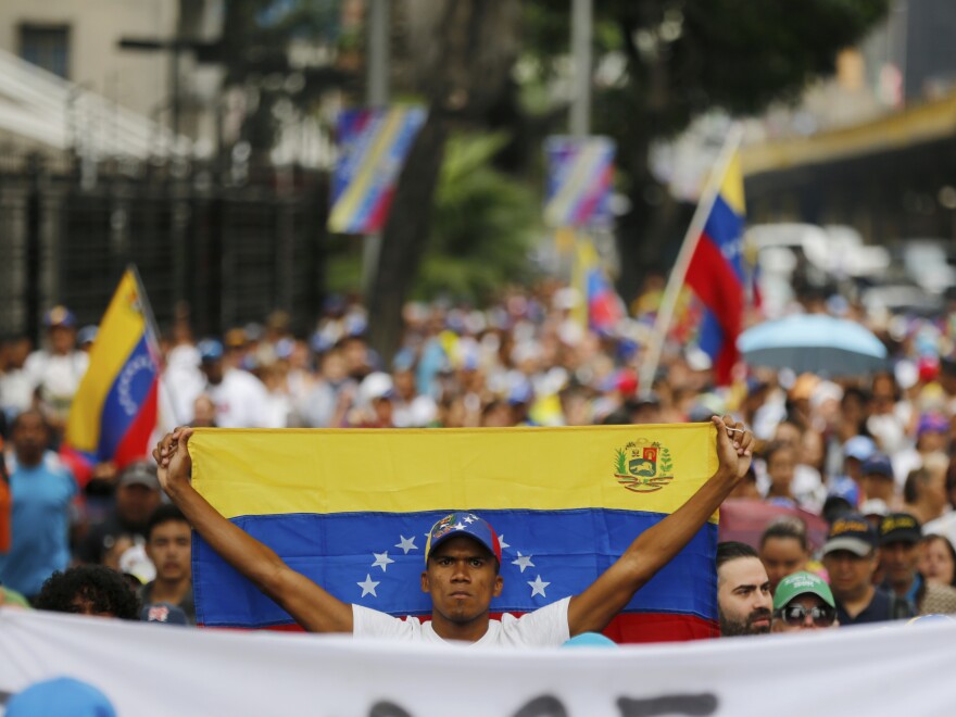 An opposition member holds a Venezuelan national flag during a protest against Maduro in Caracas on Wednesday.