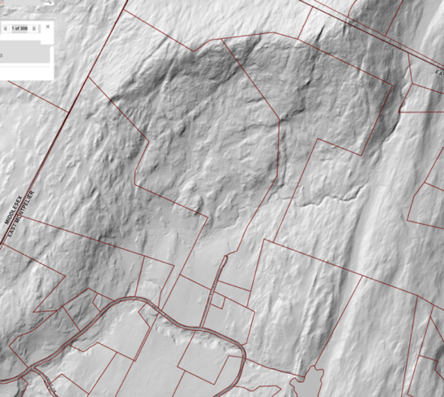 A grey and red map shows a crescent-shaped hill.