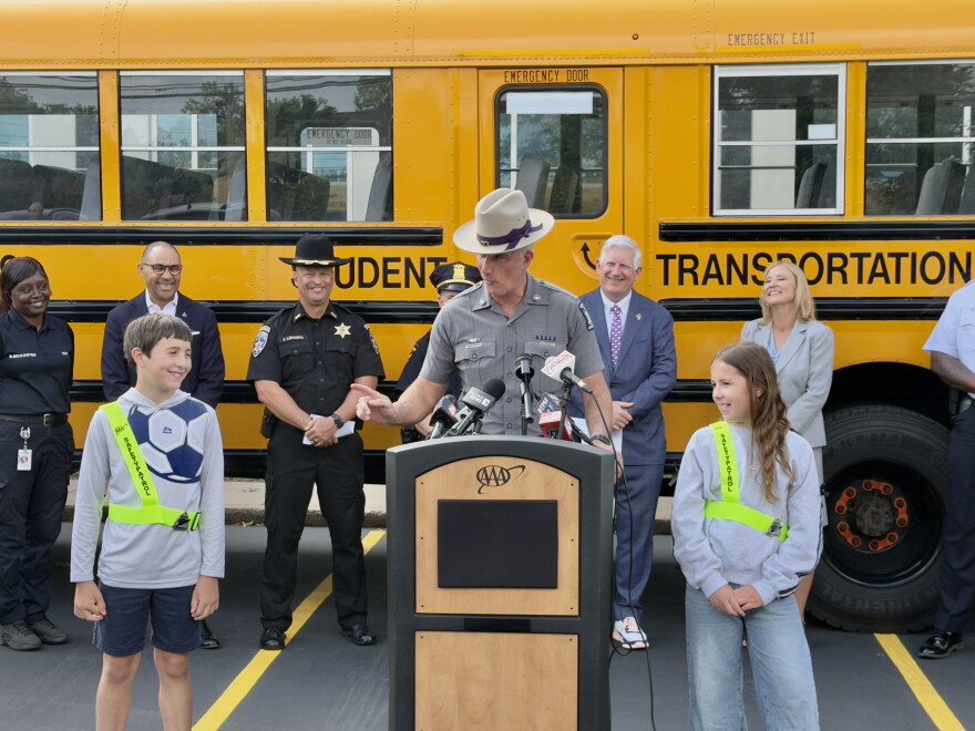 NYSP Trooper James O’Callaghan speaks with two children, Greyson and Evelyn, who are AAA Safety Patrollers at their school, during a press conference at AAA Western and Central New York Headquarters in Amherst on September 2, 2026.